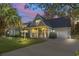 Inviting home exterior with a covered porch, lush lawn, and attached garage at twilight at 1044 Martin Ln., Conway, SC 29526