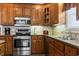 Well-equipped kitchen with stainless appliances, tile backsplash, double sink and wood cabinets at 1044 Martin Ln., Conway, SC 29526