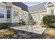 Backyard patio with an outdoor dining set, green lawn, mature trees and light green siding at 1044 Martin Ln., Conway, SC 29526