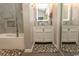 Bathroom featuring double sink vanity with decorative mirror and neutral tiling at 108 Pipers Ln. # 108, Myrtle Beach, SC 29575