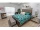 Well-appointed bedroom with a large bed, stylish decor, wood floors, and a comfortable bench at 108 Pipers Ln. # 108, Myrtle Beach, SC 29575