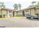 Two-story condo with light beige exterior, black shutters, and ample parking spaces at 108 Pipers Ln. # 108, Myrtle Beach, SC 29575