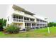 Condominium back exterior view showing screened in porches and well manicured landscape at 1100 Possum Trot Dr. # D106, North Myrtle Beach, SC 29582
