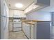 Well-lit kitchen with white appliances, tile backsplash, and an open view to the living room at 1100 Possum Trot Dr. # D106, North Myrtle Beach, SC 29582