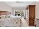 Bedroom with wooden furniture, floral bedding and outdoor access to patio at 110-1 Whitetail Way # 1, Pawleys Island, SC 29585