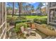 Secluded outdoor patio with seating, surrounded by lush landscaping and views of the expansive green lawn at 110-1 Whitetail Way # 1, Pawleys Island, SC 29585