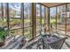Bright sunroom featuring wicker furniture, hardwood floors and multiple windows offering scenic outdoor views at 110-1 Whitetail Way # 1, Pawleys Island, SC 29585