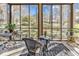 Bright sunroom featuring wicker furniture, hardwood floors and multiple windows offering scenic outdoor views at 110-1 Whitetail Way # 1, Pawleys Island, SC 29585