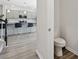 Bathroom with a toilet and a partial view of a well lit kitchen at 1102 Boswell Ct., Conway, SC 29526