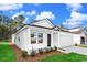 Charming one-story home featuring white siding, black door, attached garage, and a neatly landscaped front yard at 1217 Willow Oaks Way, Conway, SC 29526