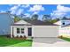 New construction home with white siding, black door, attached garage, and manicured lawn under sunny skies at 1217 Willow Oaks Way, Conway, SC 29526
