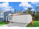 View of the side of this house featuring an attached two-car garage, white siding, and manicured lawn at 1217 Willow Oaks Way, Conway, SC 29526