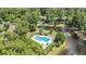 An aerial view shows a community pool, pond with a fountain, and houses surrounded by mature trees at 1221 Tidewater Dr. # 122, North Myrtle Beach, SC 29582