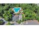 An aerial view showcases an outdoor community pool area with greenery and mature trees surrounding the site at 1221 Tidewater Dr. # 122, North Myrtle Beach, SC 29582