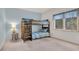 Bedroom featuring a wooden bunk bed with blue striped bedding and a sunlit window at 1221 Tidewater Dr. # 122, North Myrtle Beach, SC 29582