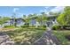 Two-story condo building with gray siding, walkways and well-maintained landscaping under a partially cloudy sky at 1221 Tidewater Dr. # 122, North Myrtle Beach, SC 29582