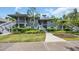 Two-story condo building with gray siding and well-maintained landscaping under a partially cloudy sky at 1221 Tidewater Dr. # 122, North Myrtle Beach, SC 29582