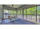 Sunroom with a round table and chairs, screened windows, and view of wooded exterior at 1221 Tidewater Dr. # 122, North Myrtle Beach, SC 29582