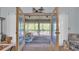 View of a screened sunroom with seating, accessible via glass paneled double doors with white curtains at 1221 Tidewater Dr. # 122, North Myrtle Beach, SC 29582