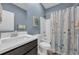 Bright bathroom featuring a shower with a floral curtain and a modern vanity with a white countertop at 1352 Jolly Roger Dr., North Myrtle Beach, SC 29582