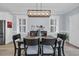 This is a dining room with black chairs, a brown table, and a modern light fixture at 1352 Jolly Roger Dr., North Myrtle Beach, SC 29582
