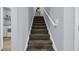 Carpeted staircase with white handrail leading to the upper level, adjacent to the laundry room at 1352 Jolly Roger Dr., North Myrtle Beach, SC 29582