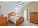 Comfortable bedroom with a wooden frame bed, ceiling fan, and warm natural light at 1407 Sunningdale Ln., Myrtle Beach, SC 29588