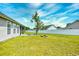 A spacious backyard features a fire pit and lush lawn, enclosed by a white fence, perfect for outdoor enjoyment at 1412 Reid Ct., Myrtle Beach, SC 29588