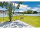 Expansive backyard with a well-maintained lawn, white fencing, a stone firepit, and a grey wooden deck at 1412 Reid Ct., Myrtle Beach, SC 29588