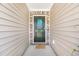 Close-up of the front door with a decorative wreath, and a neutral colored mat at 142 Pine Forest Dr., Conway, SC 29526