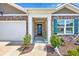 Inviting covered front porch with brick accents, landscaping and a decorative wreath on the front door at 142 Pine Forest Dr., Conway, SC 29526