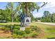 Neighborhood entrance sign 'Pine Forest' surrounded by trees, flowers and green landscaping at 142 Pine Forest Dr., Conway, SC 29526