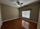 Bright bedroom with hardwood floors, fan, and window with a bamboo blind at 1428 Saint Thomas Circle # B-1, Myrtle Beach, SC 29577