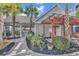 Charming clubhouse with a covered patio, garden beds, and a pergola over the entrance and a sidewalk leading to the entry at 149 Ella Kinley Circle # 302, Myrtle Beach, SC 29588