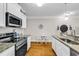 Modern kitchen featuring white cabinets, stainless steel appliances, granite countertops, and hardwood floors at 149 Ella Kinley Circle # 302, Myrtle Beach, SC 29588