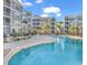 View of the community pool, surrounded by lounge seating, tables, and modern apartment buildings with screened porches at 149 Ella Kinley Circle # 302, Myrtle Beach, SC 29588
