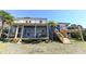 Expansive backyard with a screened porch, deck and staircase leading up to a rooftop deck perfect for outdoor entertaining at 1931 Lakeview Circle, Surfside Beach, SC 29575