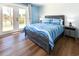 Bedroom featuring a full bed, nightstands, wood floors, patio doors and a view of the lake at 1931 Lakeview Circle, Surfside Beach, SC 29575