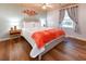 Bedroom with a queen bed, nightstands, wood floors, and bright window with gray curtains at 1931 Lakeview Circle, Surfside Beach, SC 29575