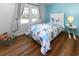 Charming bedroom features a twin bed with nautical bedding, wood floors, and a bright window at 1931 Lakeview Circle, Surfside Beach, SC 29575