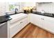 Well-lit kitchen with a white farmhouse sink, modern faucet, and white cabinets at 1931 Lakeview Circle, Surfside Beach, SC 29575
