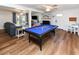 Bright living room featuring a pool table, sofa, and a fireplace, with wood floors and ample natural light at 1931 Lakeview Circle, Surfside Beach, SC 29575