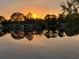 Scenic sunset view reflecting over the water with homes along the shoreline offering serene waterfront living at 1931 Lakeview Circle, Surfside Beach, SC 29575