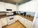 Well-lit kitchen featuring white cabinetry and appliances and granite countertops at 2007 S Ocean Blvd. # 1506, Myrtle Beach, SC 29577
