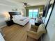 Inviting bedroom features a king bed, a sitting area, and a sliding glass door to the balcony with ocean views at 2007 S Ocean Blvd. # 1506, Myrtle Beach, SC 29577