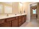 Bright bathroom with double vanity, dark wood cabinets, and neutral tile flooring at 210 Natures View Circle, Pawleys Island, SC 29585