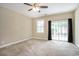 Spacious carpeted bedroom featuring a ceiling fan and sliding glass door to the outside at 210 Natures View Circle, Pawleys Island, SC 29585