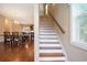 Staircase with wooden handrail and hardwood flooring visible into the kitchen and dining area at 210 Natures View Circle, Pawleys Island, SC 29585