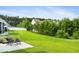 Expansive backyard with lush green grass, mature trees and patio with lawn chairs at 314 Bumble Circle, Murrells Inlet, SC 29576
