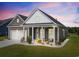 Attractive single-story house with well-kept lawn, front porch seating, and attached two-car garage at dusk at 314 Bumble Circle, Murrells Inlet, SC 29576